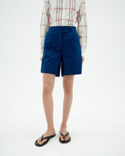 Person in blauer Shorts und gemusterter Bluse
