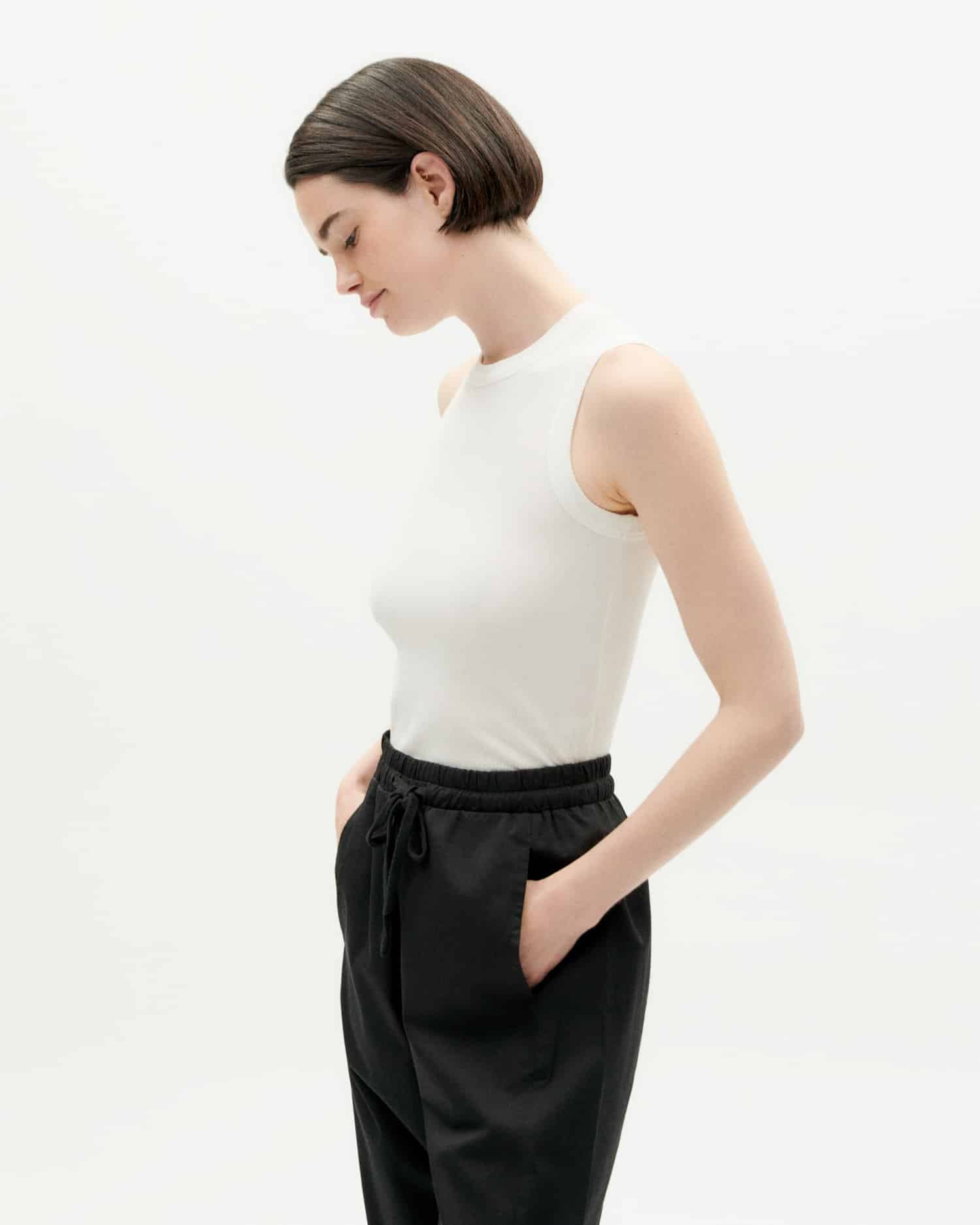 Frau in weißem Top und schwarzer Hose