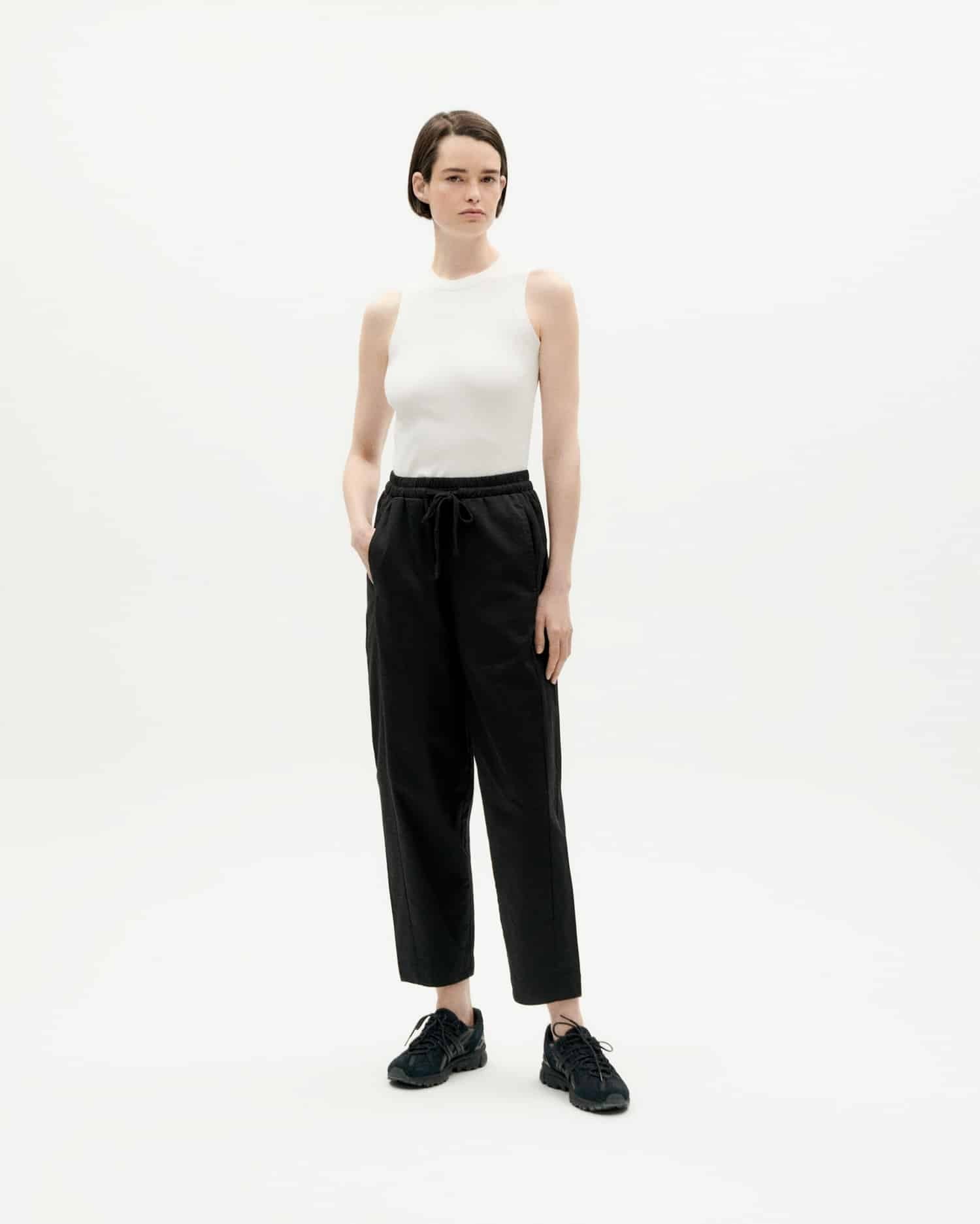 Frau in weißem Top und schwarzer Hose