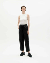 Frau in weißem Top und schwarzer Hose