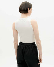 Frau in weißem Top und schwarzer Hose von hinten