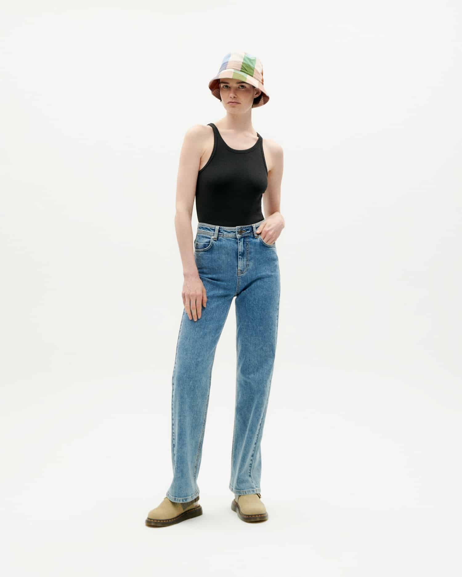 Frau in Jeans und schwarzem Top mit buntem Hut