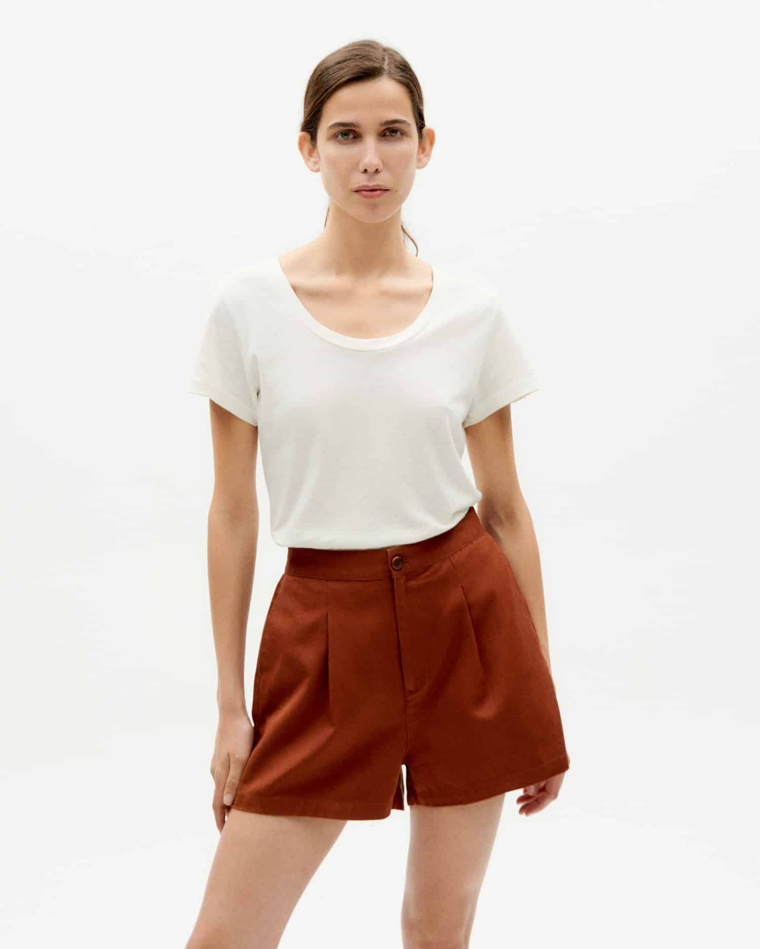 Frau in weißem T-Shirt und roter Shorts.