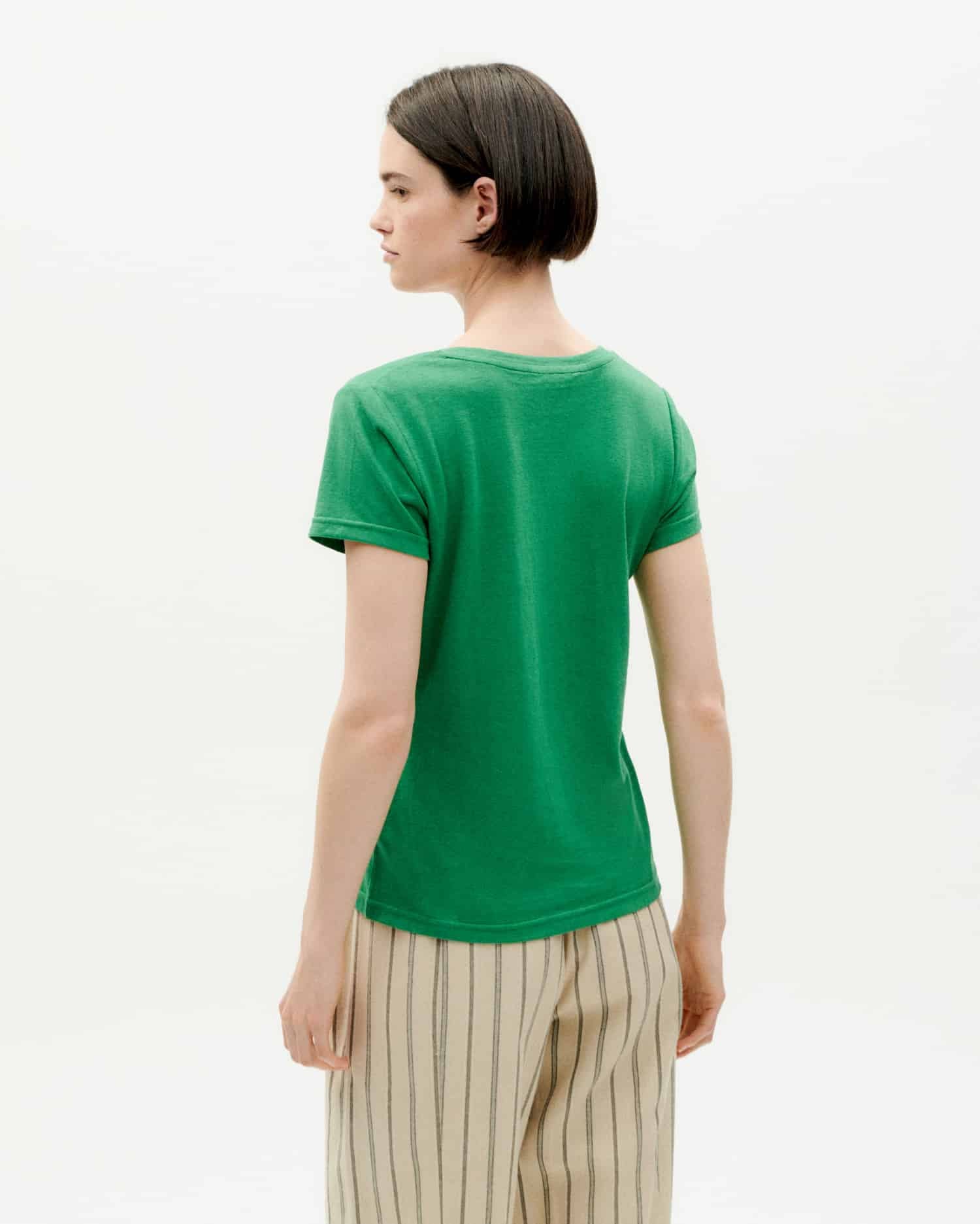 Frau in grünem T-Shirt von hinten betrachtet.