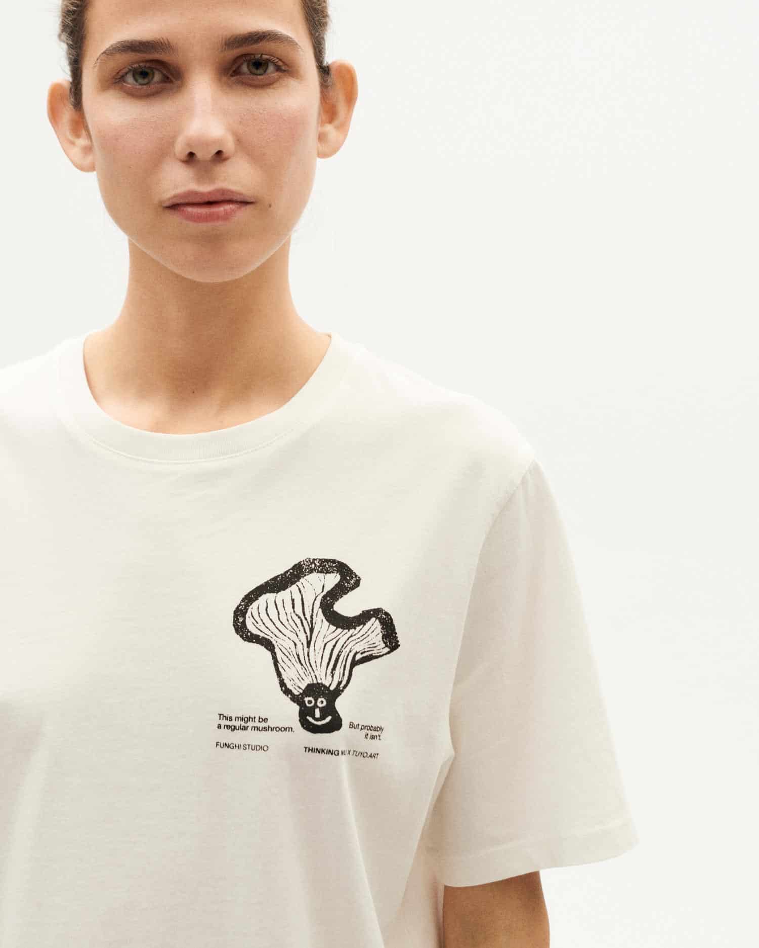 Frau in weißem T-Shirt mit Pilzdesign