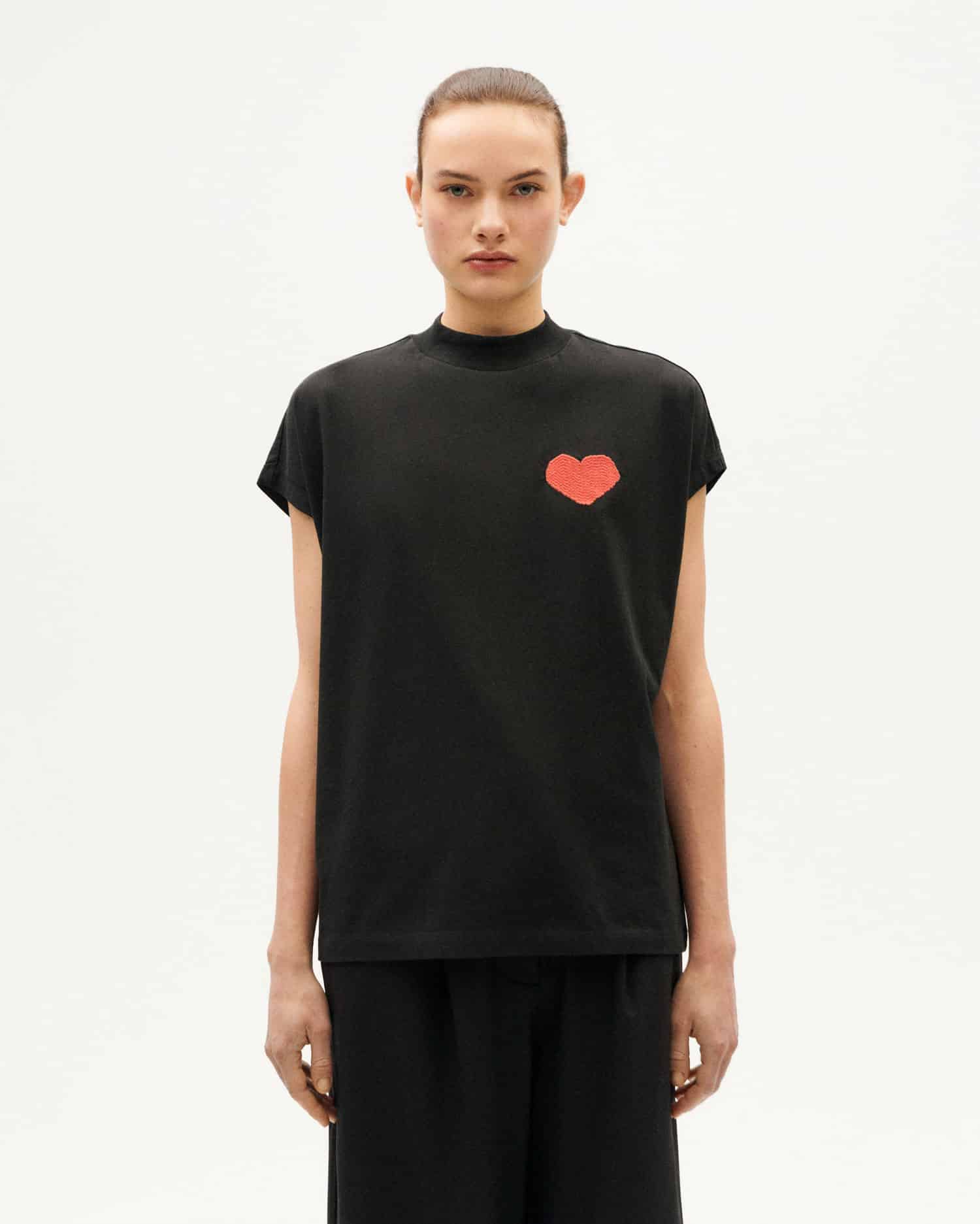 Frau in schwarzem T-Shirt mit rotem Herz