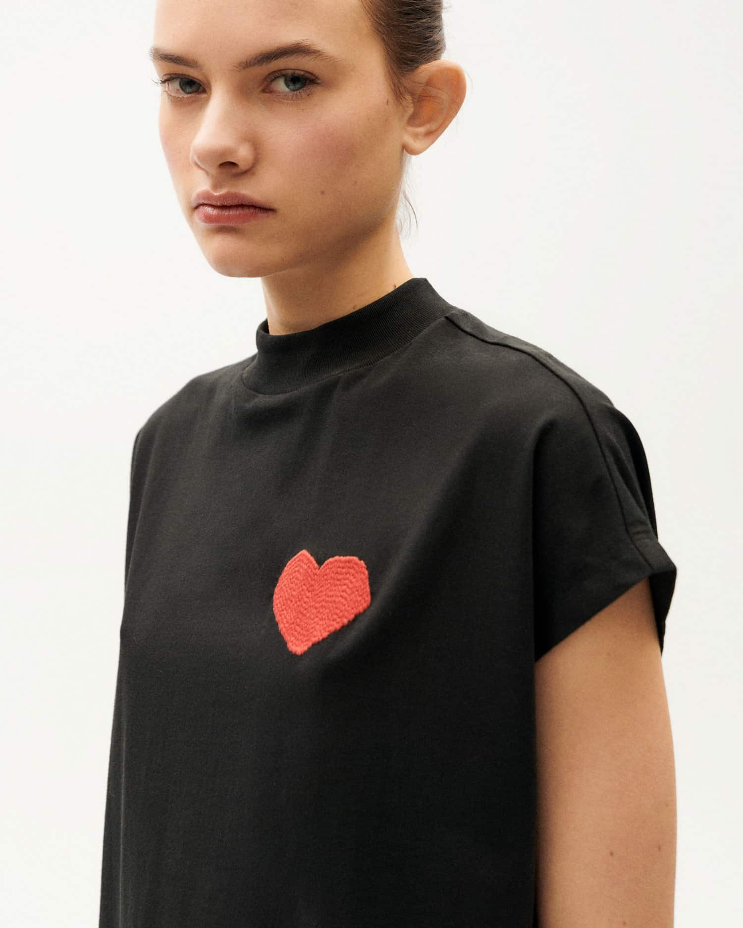 Frau in schwarzem Shirt mit rotem Herz