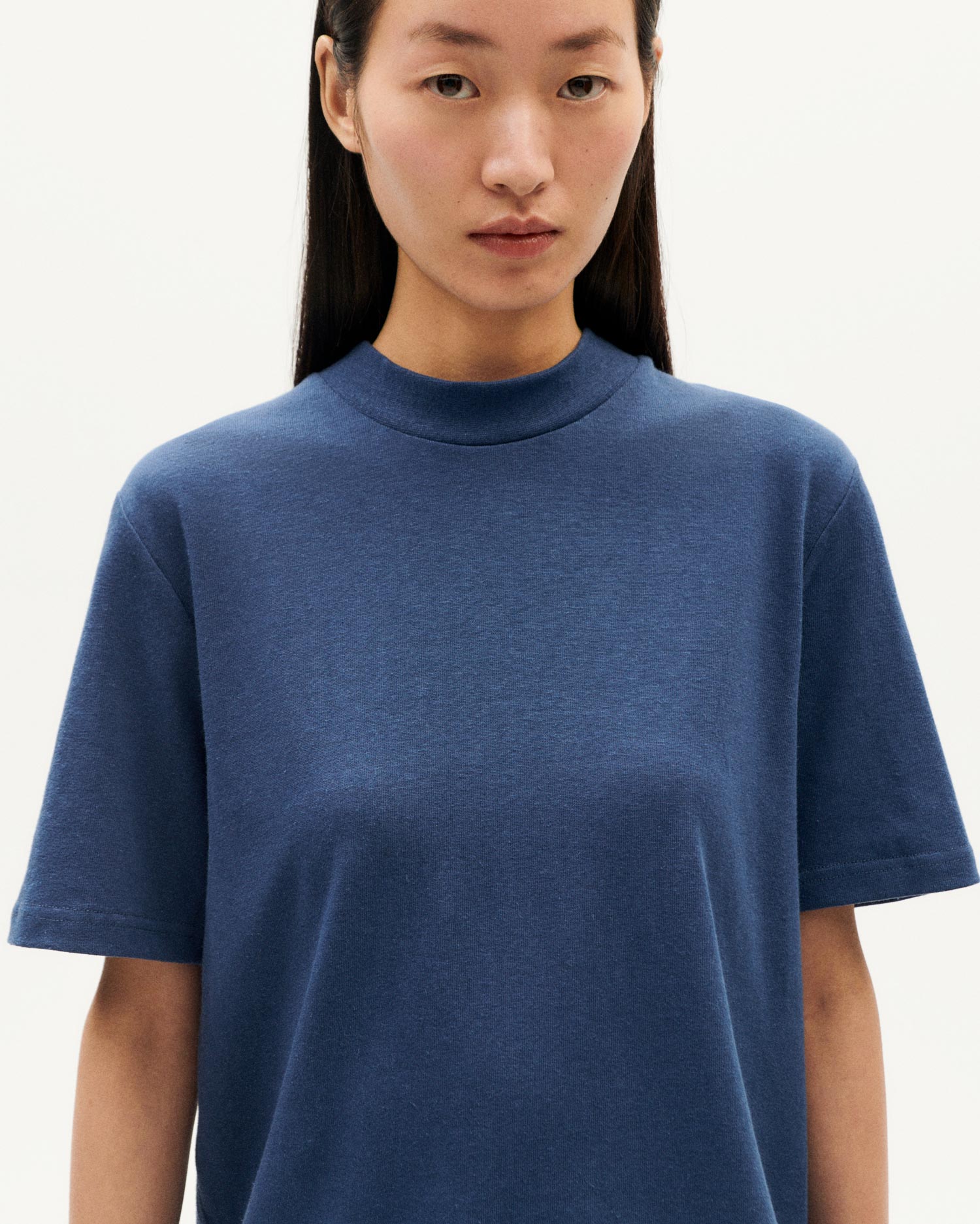 Frau in blauem T-Shirt vor weißem Hintergrund