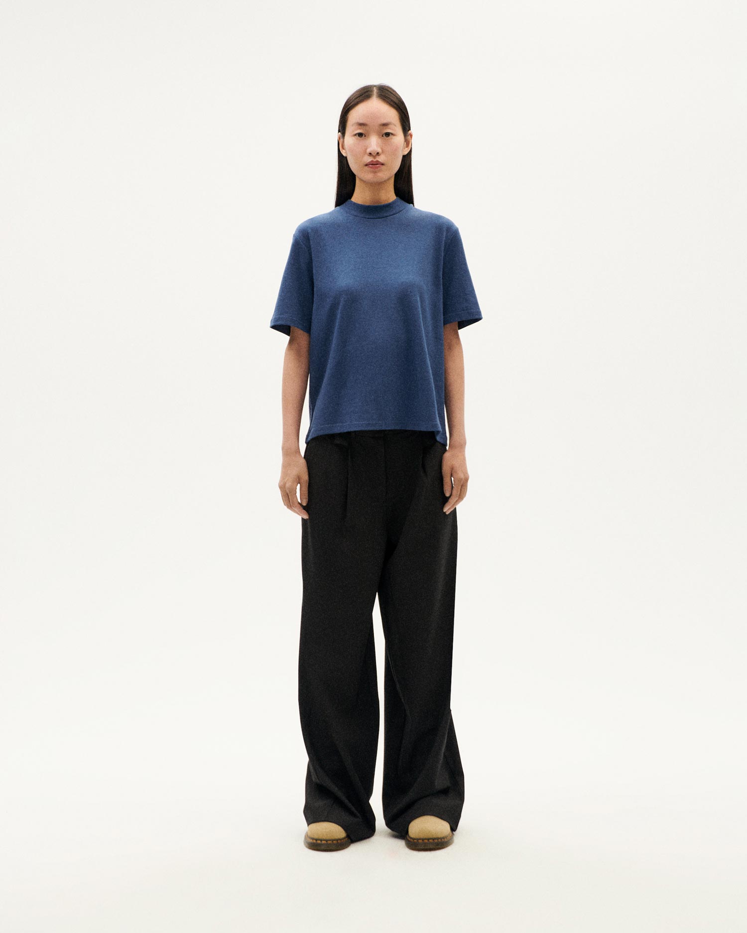 Frau in blauem Oberteil und schwarzer Hose